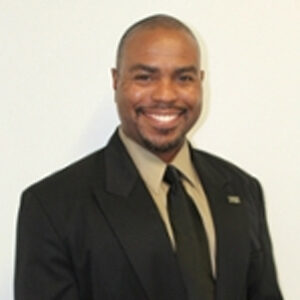 A man in a suit and tie, smiling for the camera at a Georgia corporate event.